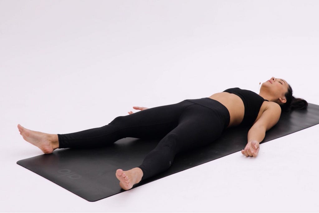 A woman in black yoga attire doing the “cobra yoga pose”