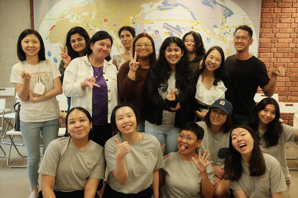 A group of people, some sitting, some standing, smiling at the camera