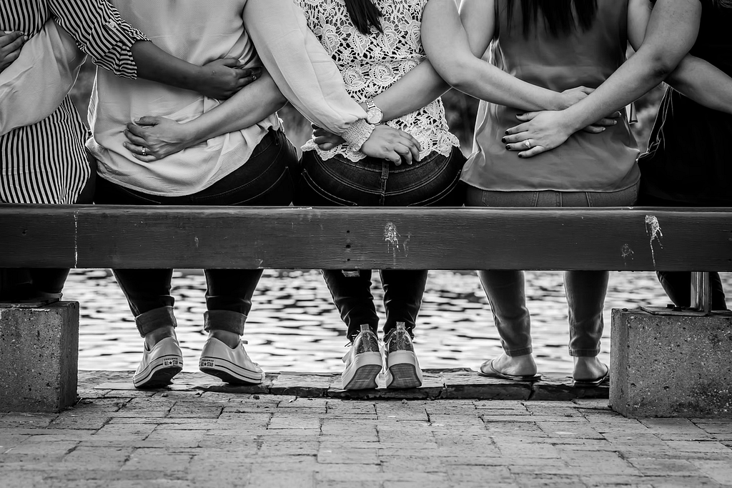 Women embracing each other on a bench
