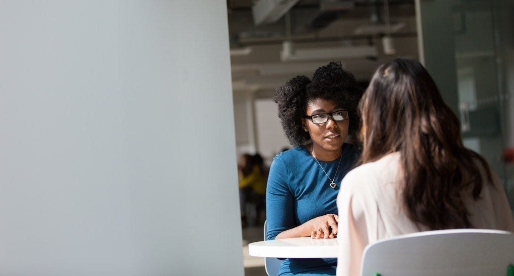 Two women having a business meeting while sitting at a table