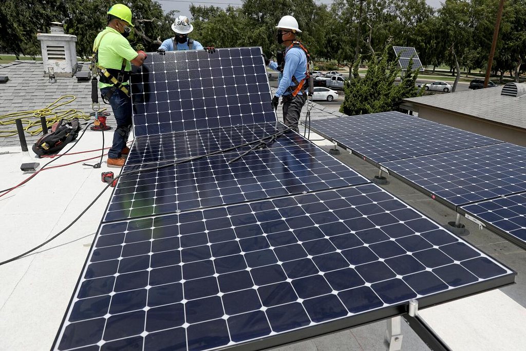 installers install solar panels on the roof