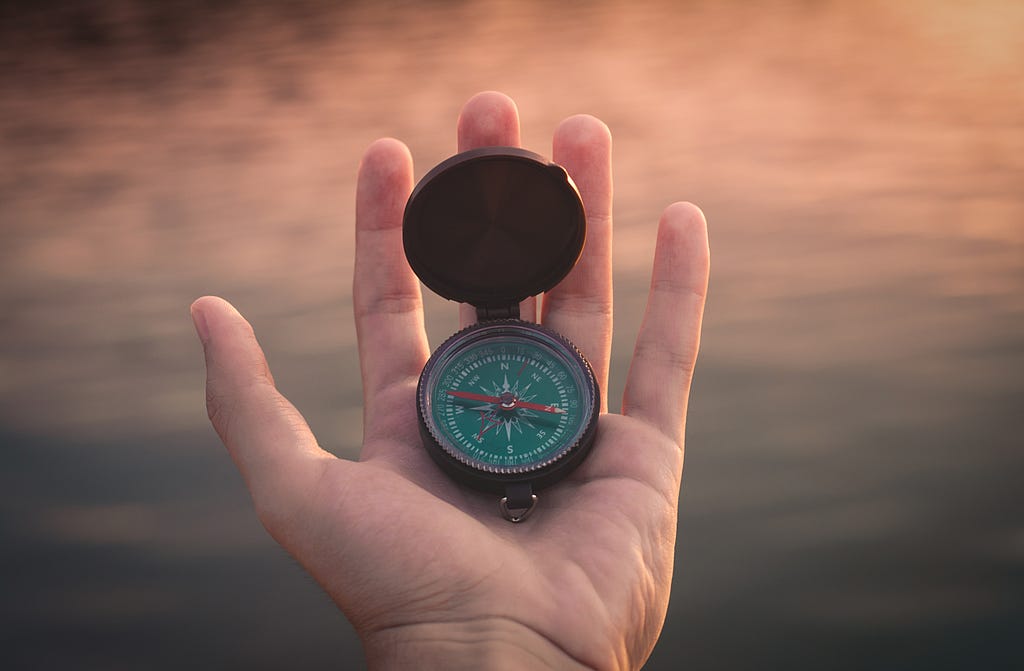 Person holds out compass to understand where to go next