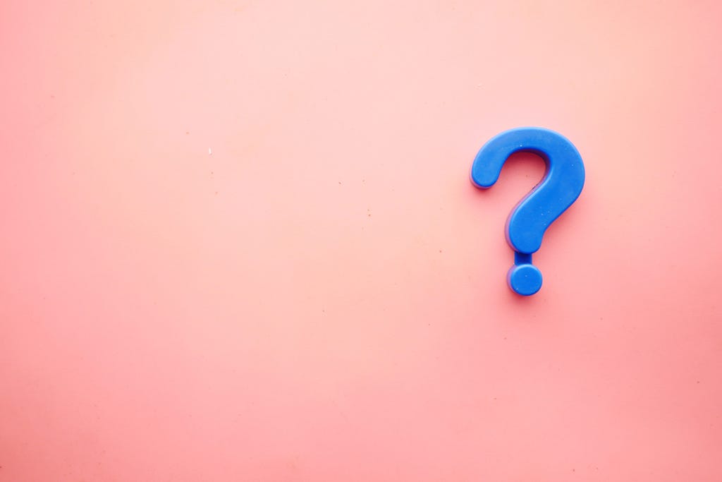 A blue magnetic question mark is placed off-center on a pink gradient background.