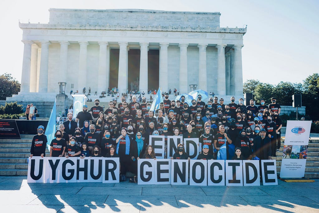a group photo of protesters against uyghur genocide