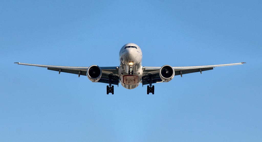 An image of a commercial aircraft landing. The plane is flying directly toward the camera.