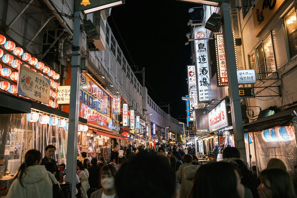 A shopping street packed with people at night.