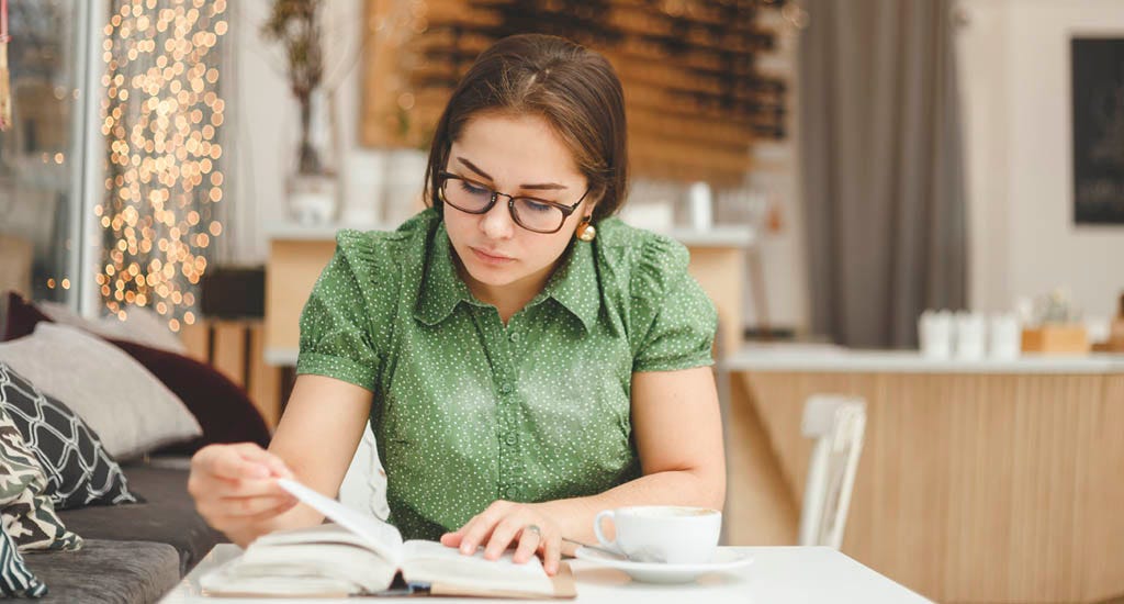 Entrepreneur reading book and drinking fresh coffee