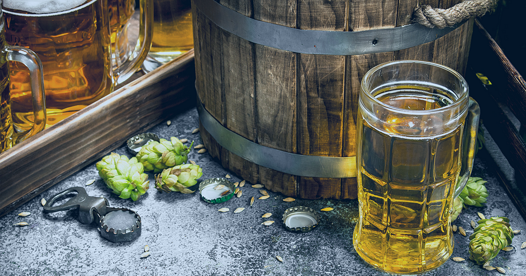 Picture showing a glass of beer, a barrel and some hops