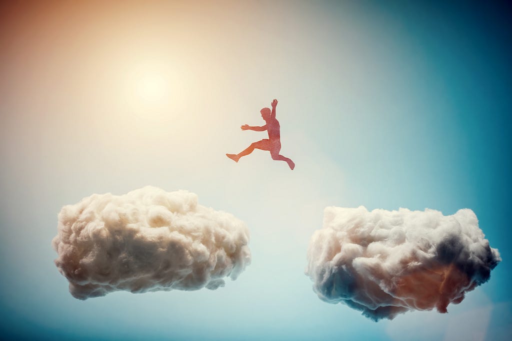 Man jumping from one cloud to another.