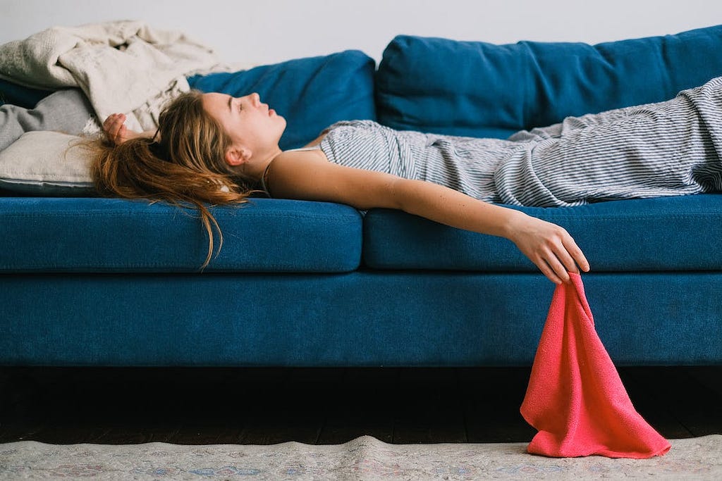 A young lady is lying on a sofa after mental exhaustion. SHVETS production/Pexels.