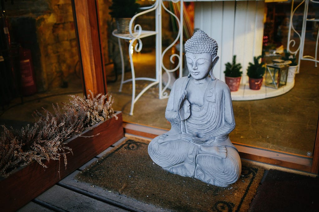 Statue of a Buddha on a door mat
