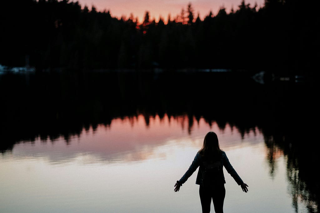 Silhoutte of a woman in a mountain lake.