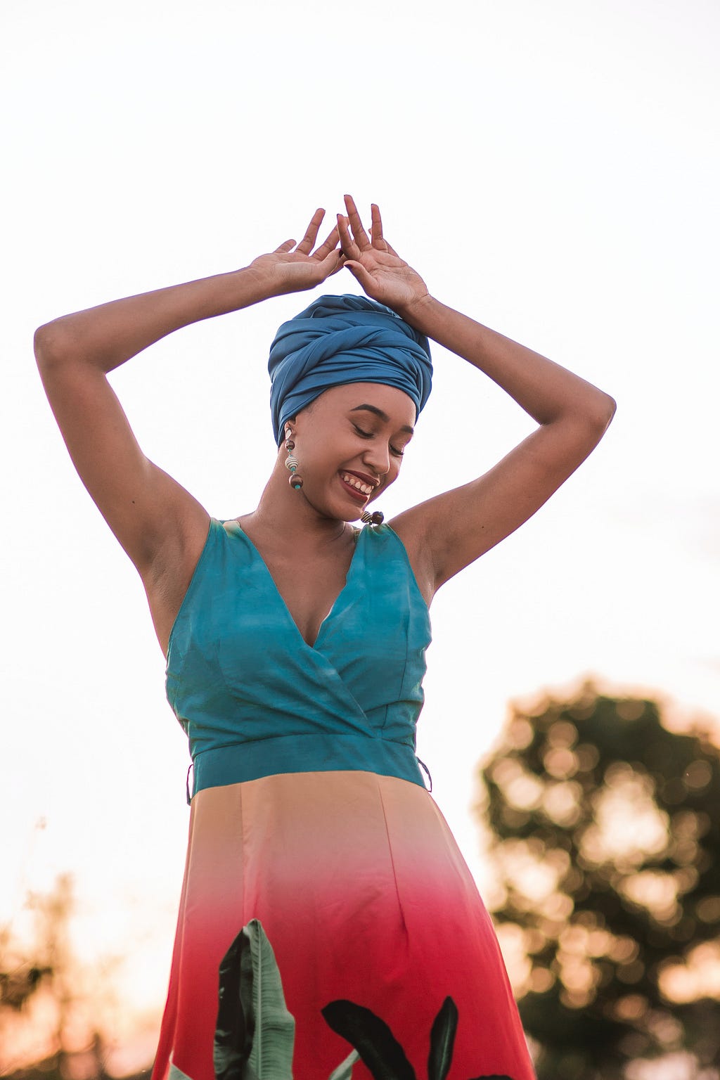 A happy young woman with her hands raise to her head