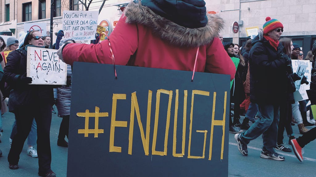 Protest poster with the words, “#Enough” written.