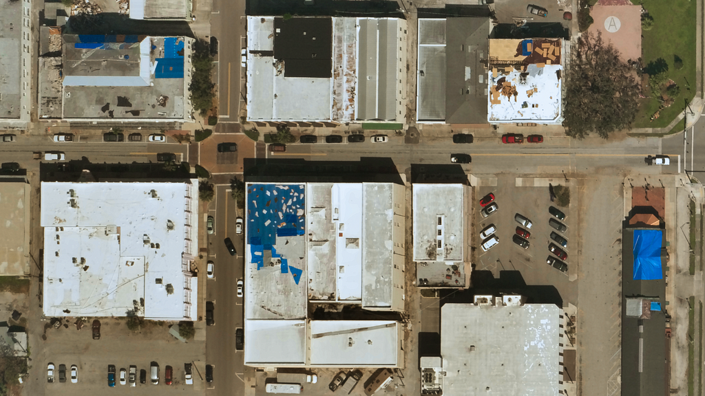 Near Space Labs’ imagery showing commercial buildings with damage to their roofs, some with blue tarps.