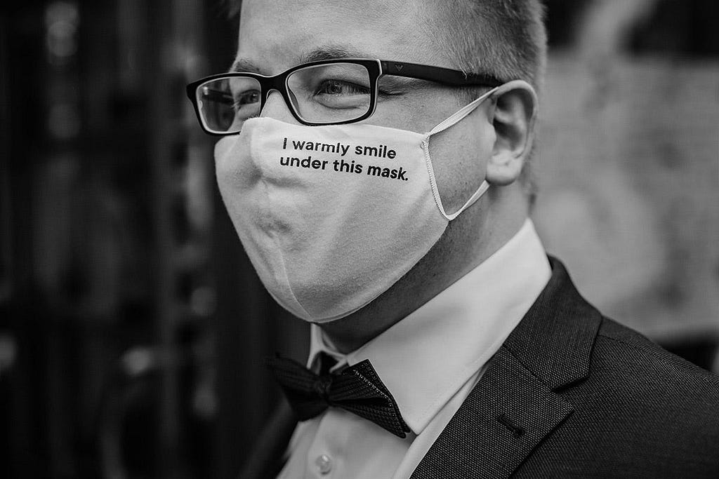 A groom wearing a mask.