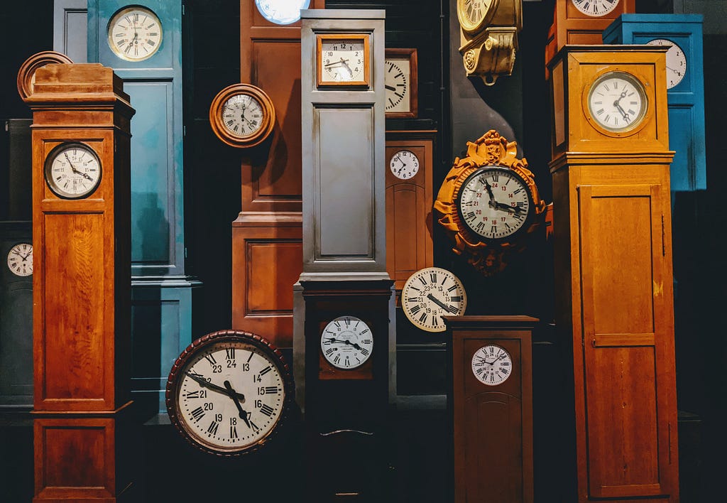 display of various clocks, most grandfather clocks in different colors.