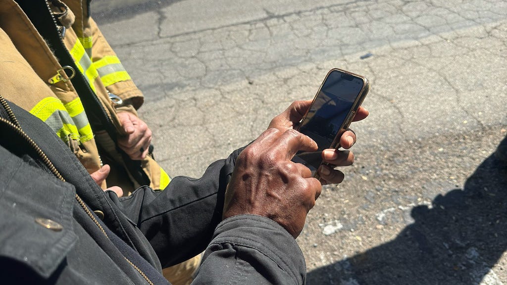 Goodsides showing video production efforts to city fire department official for greater synergy and brainstorming