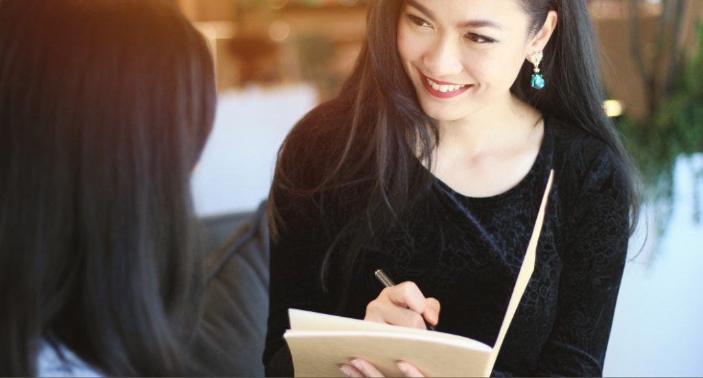 Woman listening to customer and taking notes