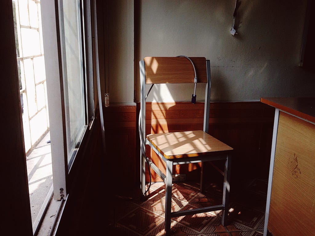 Old empty chair sits in dark classroom