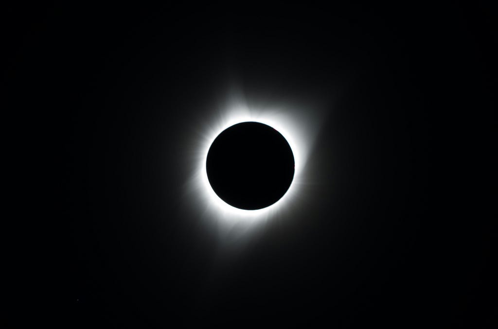 Eclipsed sun with a white corona visible