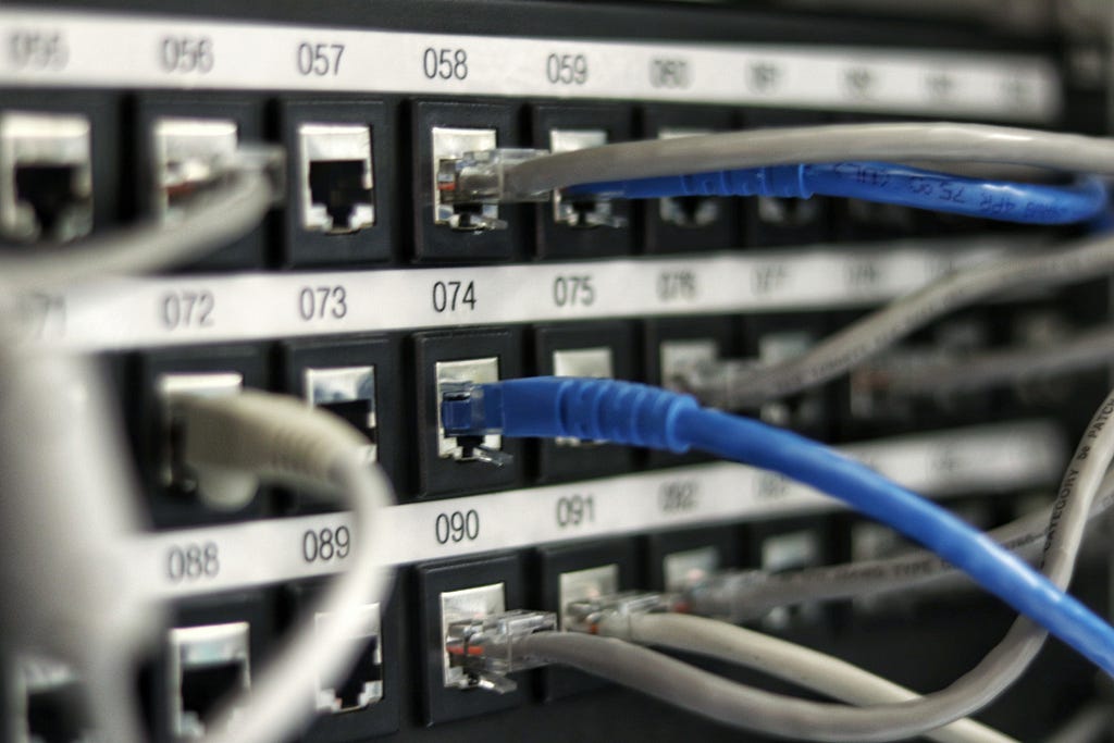 Network patch panel with Cat5 cables plugged in to various ports