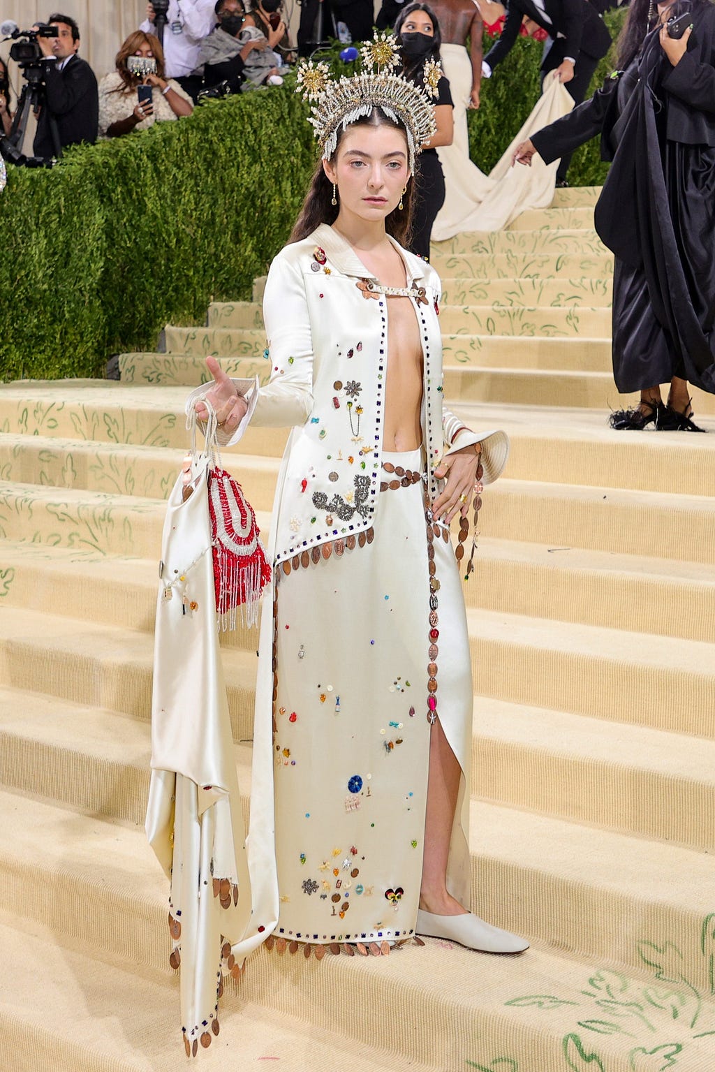 Lorde wearing and ivory Bode jacket and skirt at the entrance of the Met.