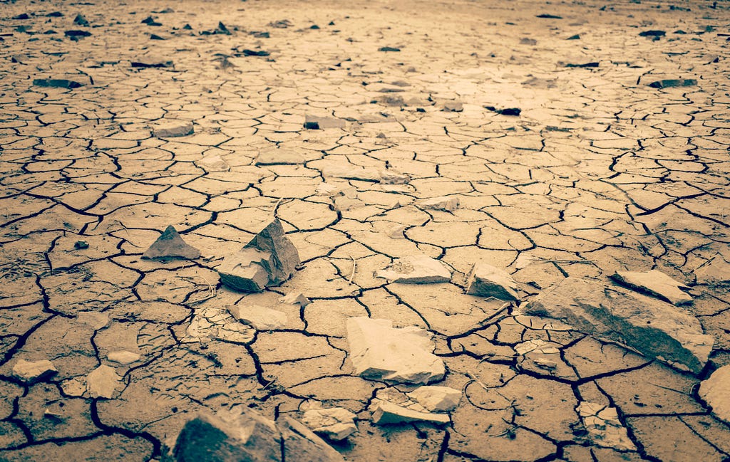 A photo of a harsh desert landscape with the ground dry and cracked
