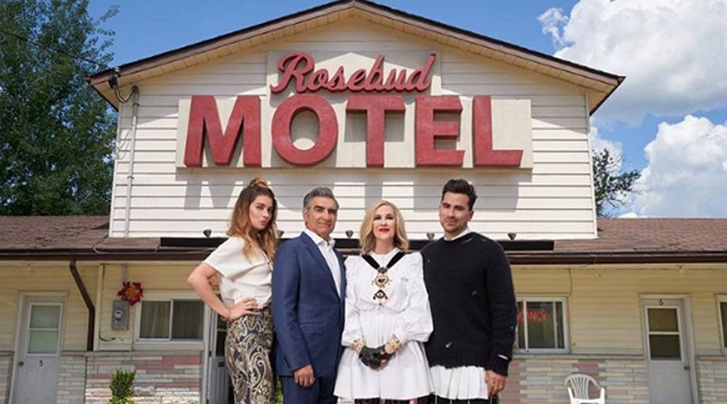 The Rose family (Alexis, Johnny, Moira, David) pose in front of their new home in Schitt’s Creek, the Rosebud Motel.