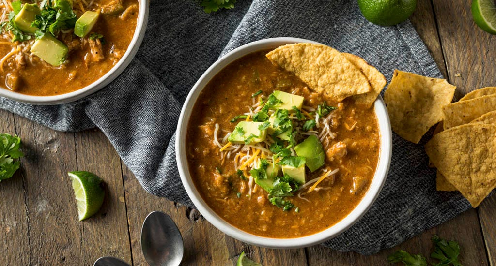 Spicy homemade chicken tortilla soup meal prep ideas for entrepreneurs with cheese, cilantro, and lime