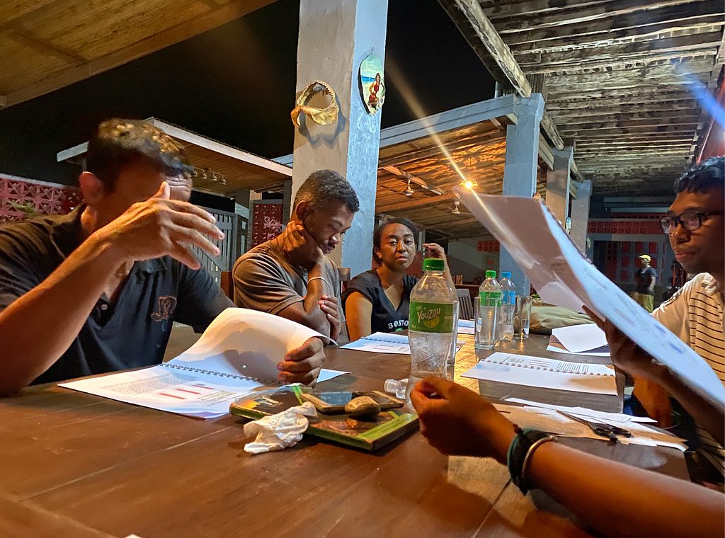 Stephie (center) with other members of the research team reviewing materials for return of results on the west coast of Madagascar.