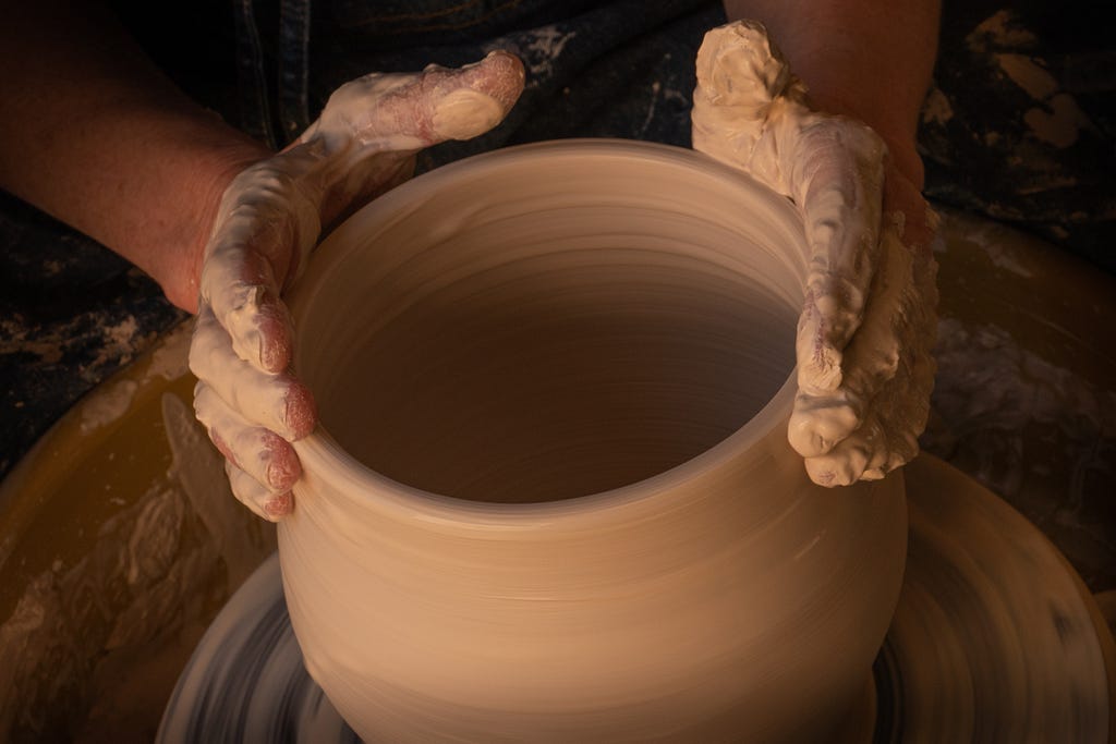 A sculptor molding clay into refined shapes.