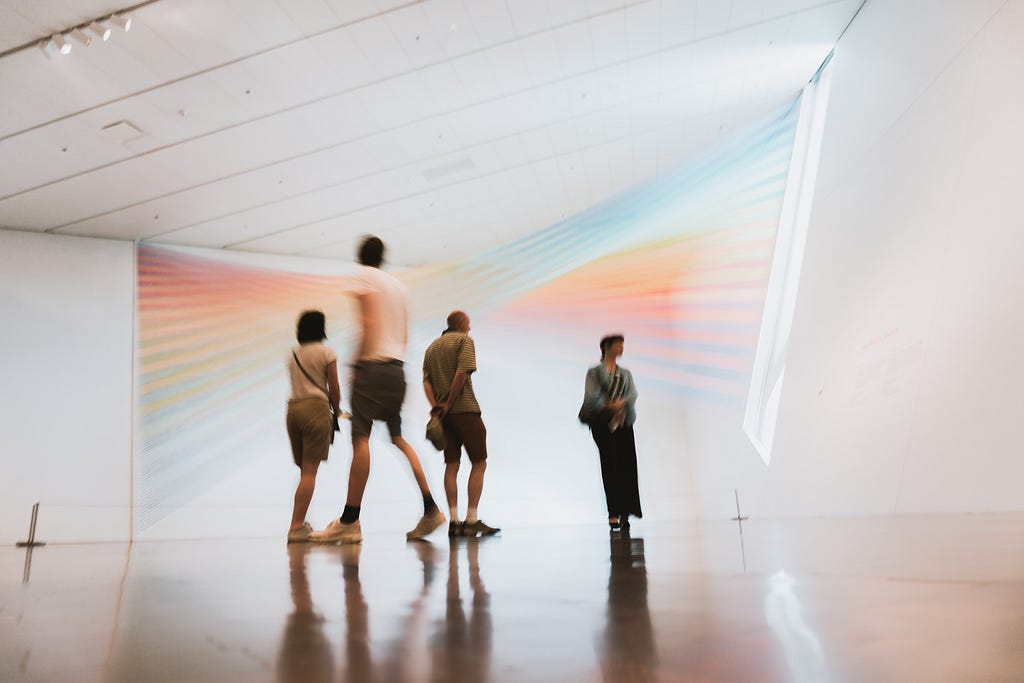 Pessoas visitando um museum e observando peças de arte moderna