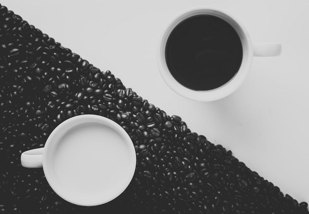 A cup of coffee and a cup of tea on a black and white yin yang background