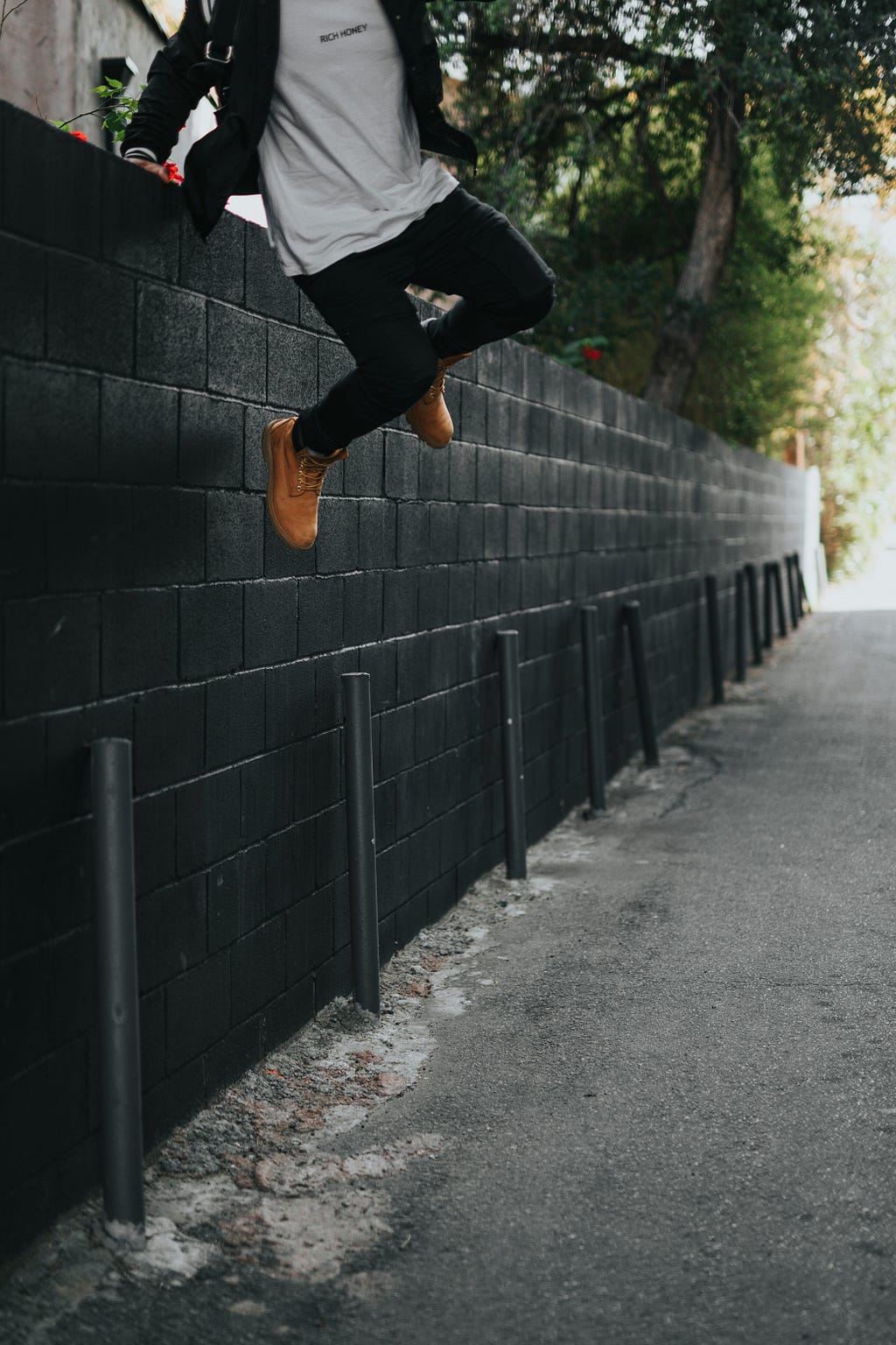 Well dressed man jumping over a wall