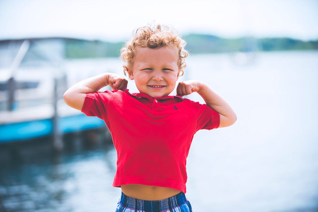 Young kid flexing his muscles