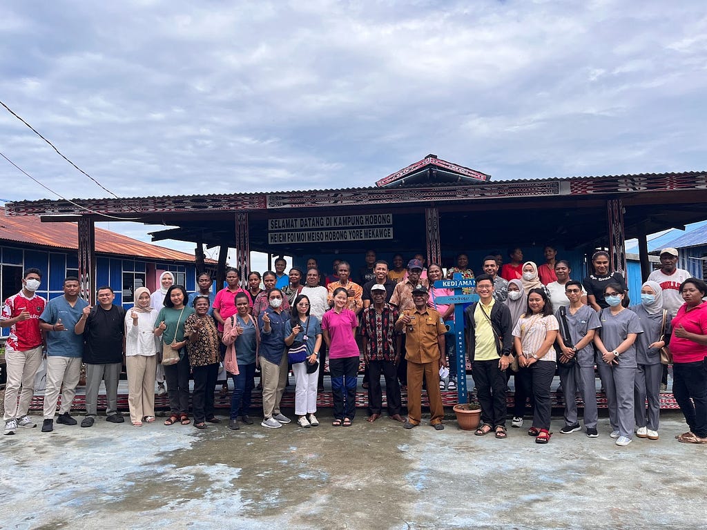 Photo of MRIN team together with local doctors, nurses, and members of the Sentani community in Hobong Village, Papua. A warm welcome from the community leads to a successful partnership.