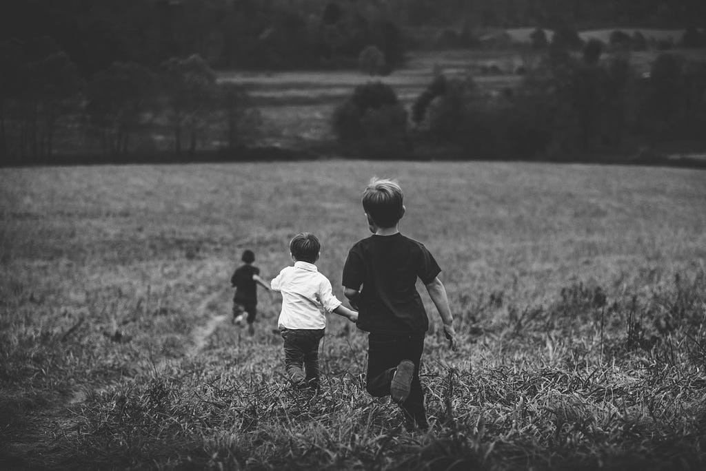 A group of kids running in a field.