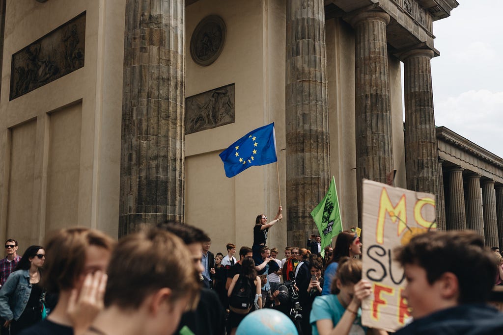 An EU flag is raised over a climate protest strike