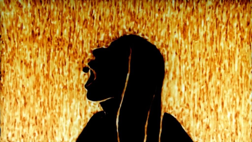 A snapshot of the movie “Ergot” showing a dark silhouette swallowing a pill on a yellow-red background