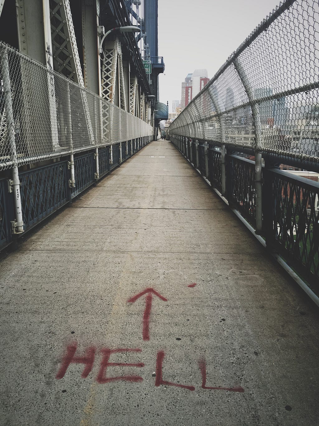 sidewalk spray painted with the world ‘hell’