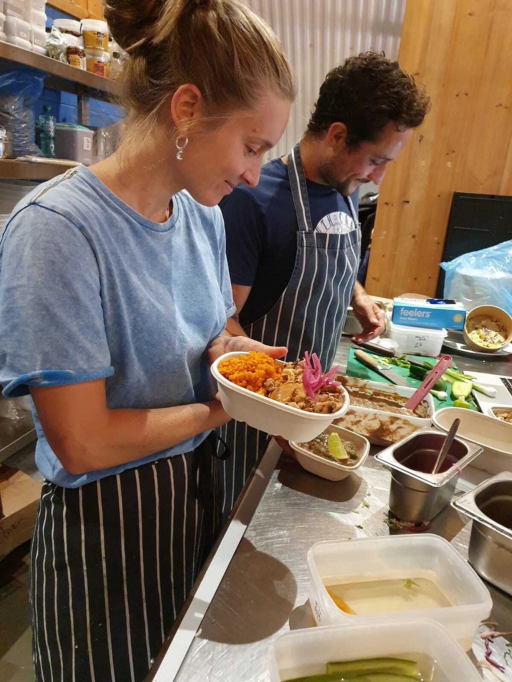 Two people filling a box with takeaway food