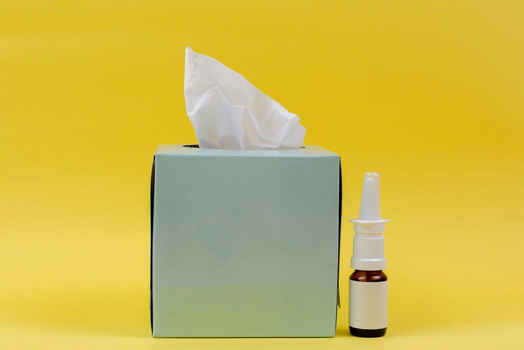 Photo of a box of kleenex and an anonymous nasal spray