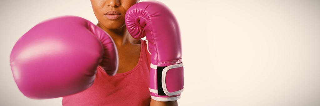 A woman in pink boxing gloves depicting overcoming adversity.