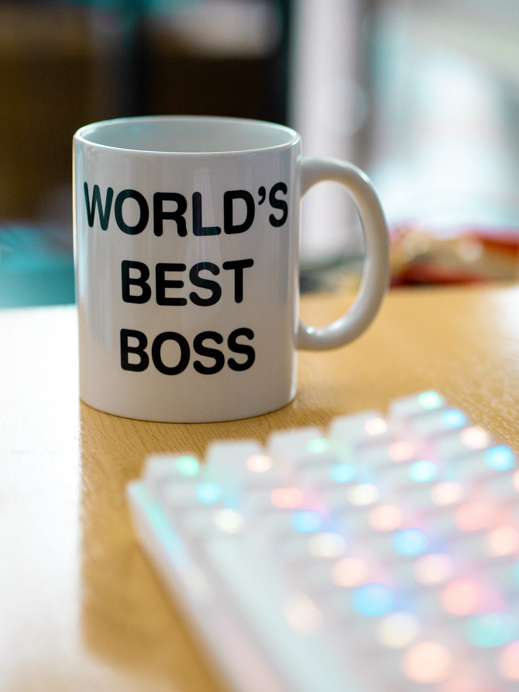 Coffee mug next to computer keyboard that says “World’s Best Boss”