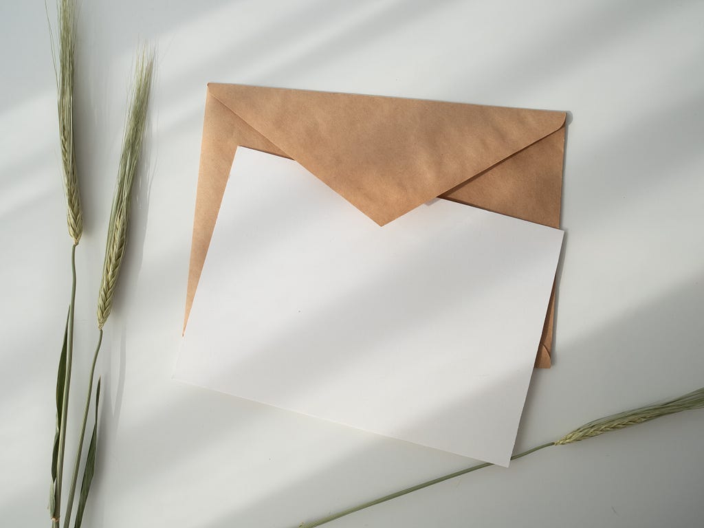 A brown envelope underneath a white blank card
