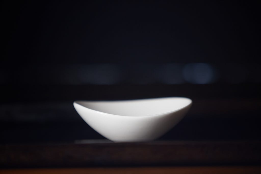 An empty bowl against a black background.