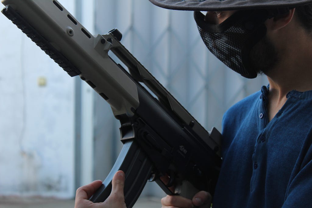 Man in mask holding a machine gun