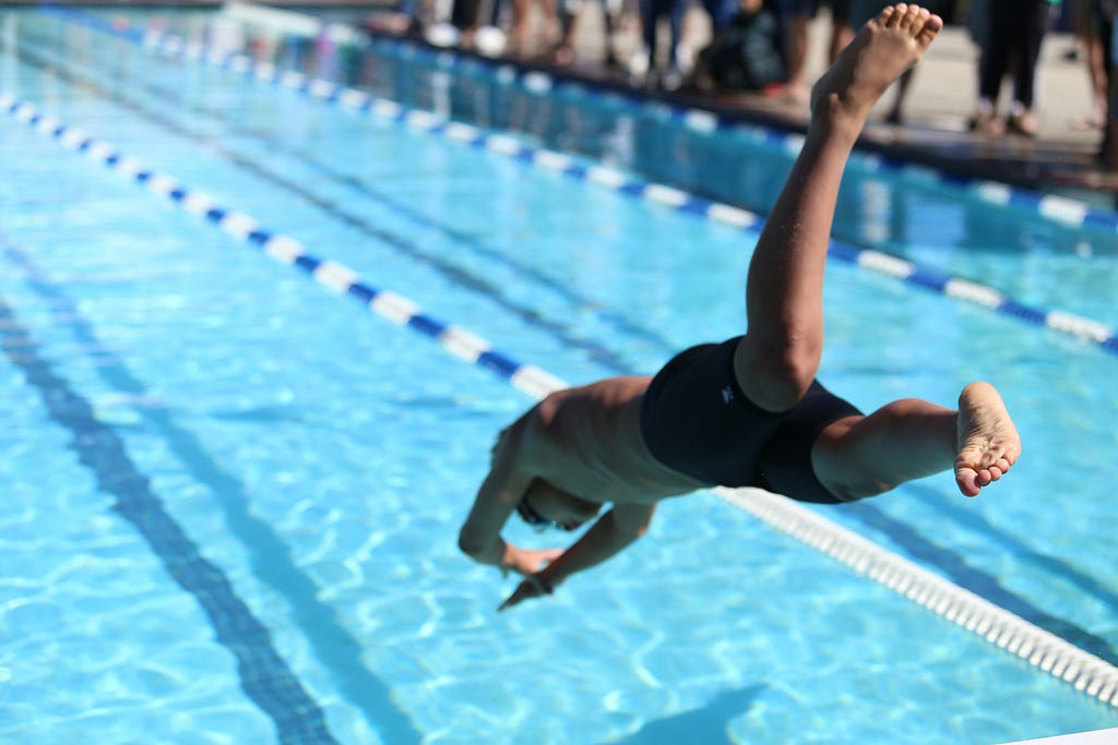 boy diving into a swimming pool