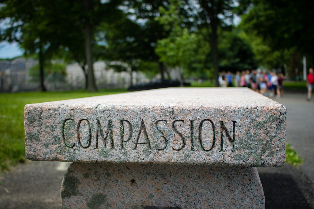 word “ compassion” carved into a stone chair